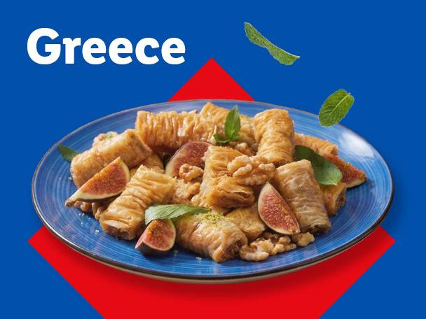 Greece: A blue plate of baklava rolls with figs, walnuts, and mint leaves on a blue and red background.