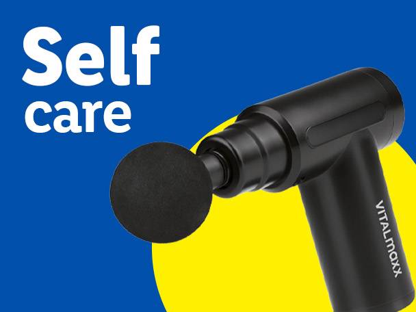 A black VITALmaxx massage gun with a round head on a blue and yellow background, with 'Self care' text.
