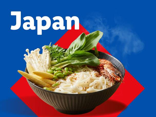 Japan: Steaming ramen bowl with noodles, shrimp, mushrooms, baby corn, and greens.