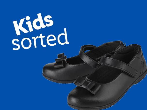 Two black children's school shoes with bows on a blue background.