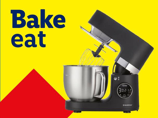 Black stand mixer with a stainless steel bowl and whisk, with text 'Bake eat' on a yellow background.