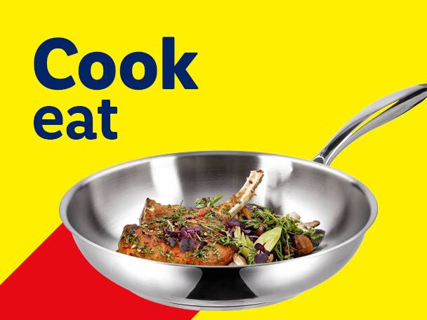 Stainless steel frying pan with cooked meat and vegetables, with text 'Cook eat'.