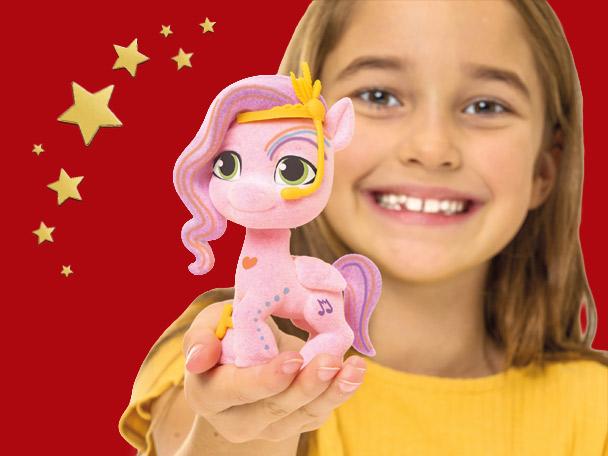 A child holding a pink toy pony with a red background and gold stars.