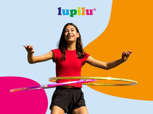 A young girl in a red shirt and black shorts hula hooping with two colorful hoops.