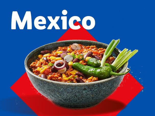 Bowl of chili con carne with red onions, corn, beans, green peppers, and spring onions. Text: Mexico.