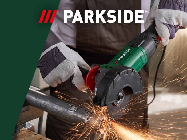 Person in work gloves using an angle grinder to cut a metal pipe, creating sparks.