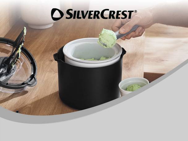 A person scooping green ice cream from an ice cream maker into a small bowl.