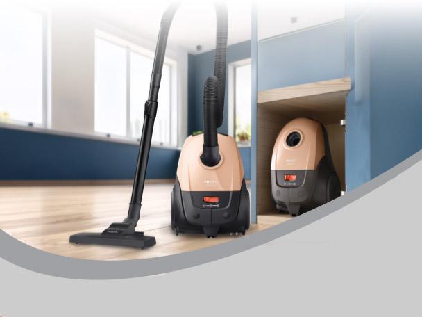Two vacuum cleaners, one in use on a wooden floor, another stored in a cabinet.