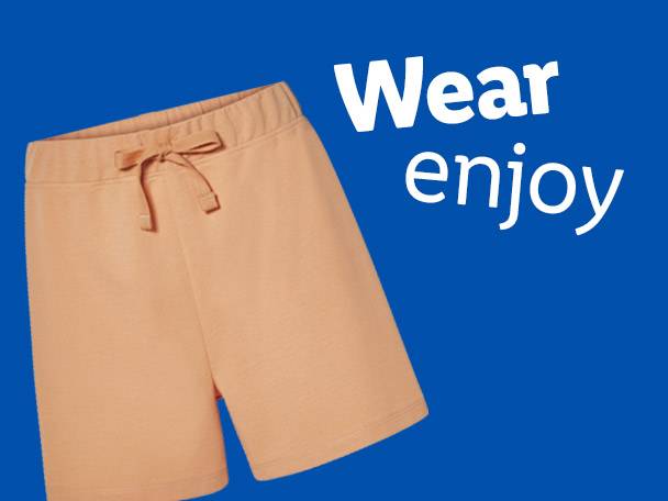Peach-colored drawstring shorts on a blue background with the text 'Wear enjoy'.
