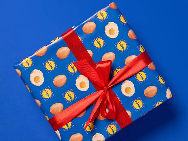 Lidl branded gift wrap with eggs and fried eggs, tied with a red ribbon.