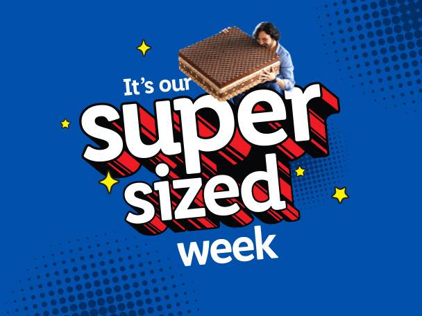 A man holding a giant wafer biscuit with the text 'It's our super sized week'.