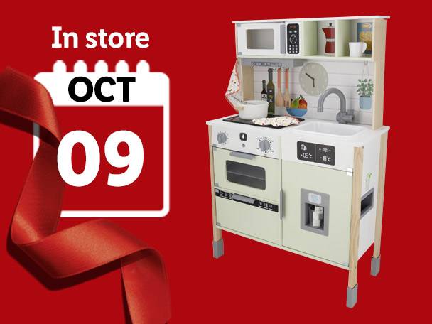 A toy kitchen set with a calendar showing 'In store OCT 09' and a red ribbon.