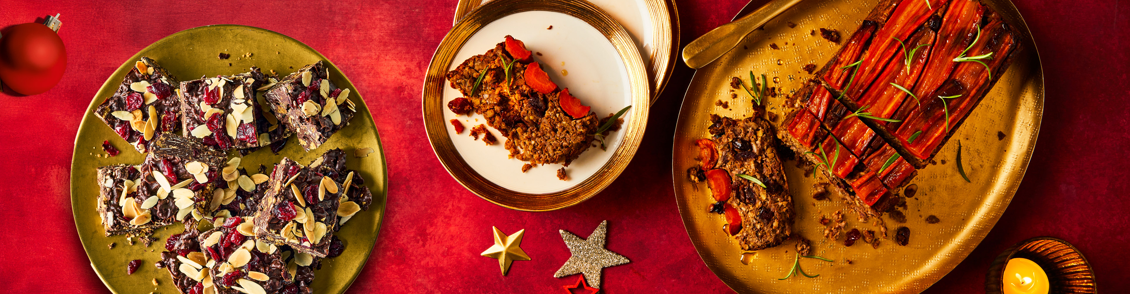 Christmas vegan desserts on golden plates, with festive decorations on a red background.
