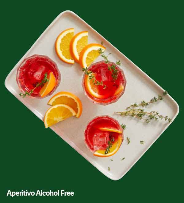 Four red aperitivo drinks with orange slices and thyme on a white tray.