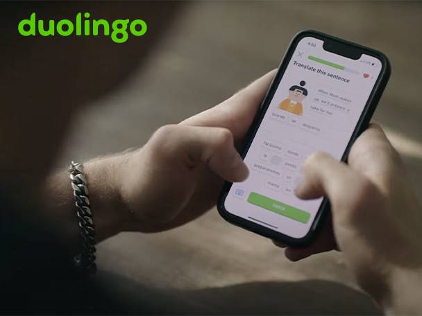 A person using a smartphone app to translate a sentence, wearing a silver bracelet.