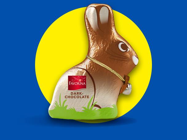 Chocolate Easter bunny with a bell, dark chocolate, on a yellow circle and blue background.