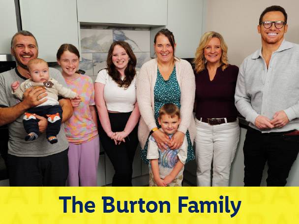 The Burton Family smiling together in a kitchen setting.