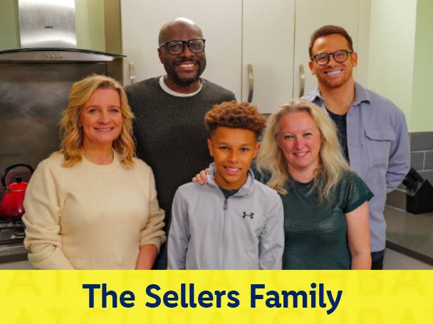 The Sellers Family smiling in a kitchen, with a red kettle visible.
