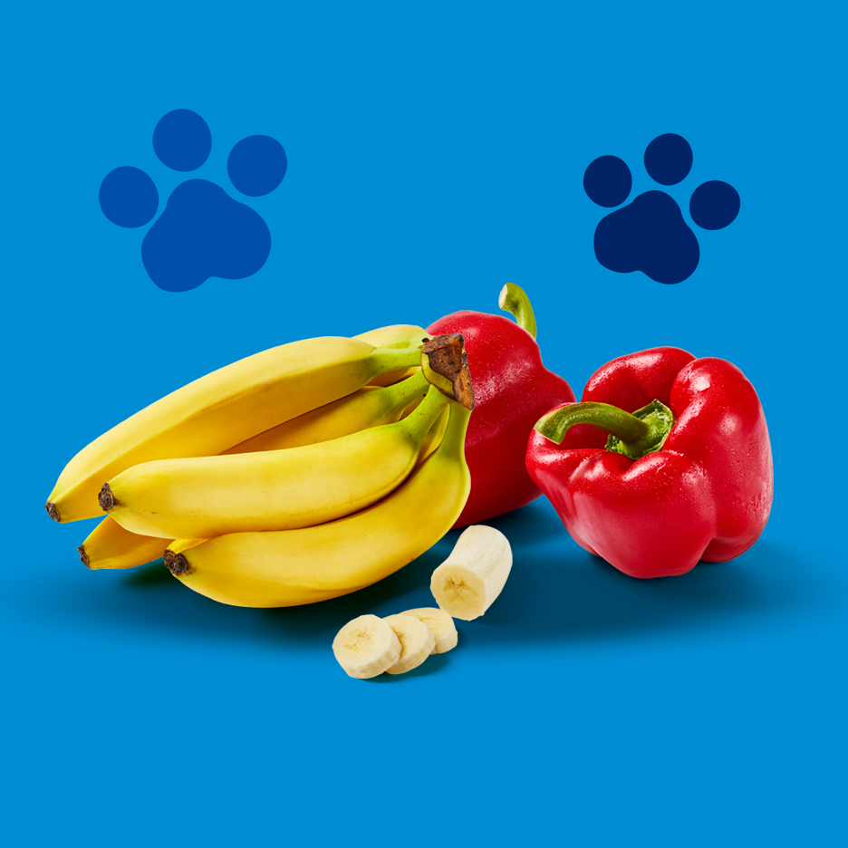 Bananas and red bell peppers with paw prints on a blue background.