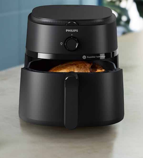 A Philips Rapid Air Technology air fryer cooks a chicken.