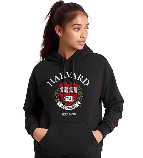A young woman wearing a black Harvard University hoodie with the crest.