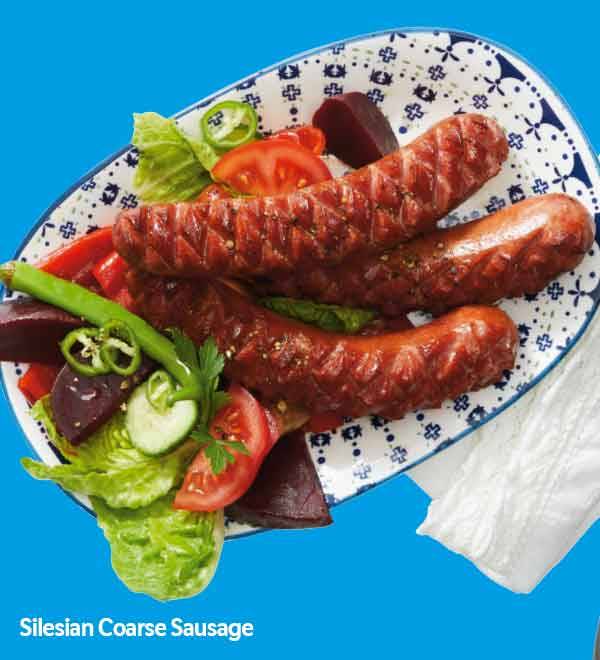 Silesian Coarse Sausage served on a plate with a vibrant salad.