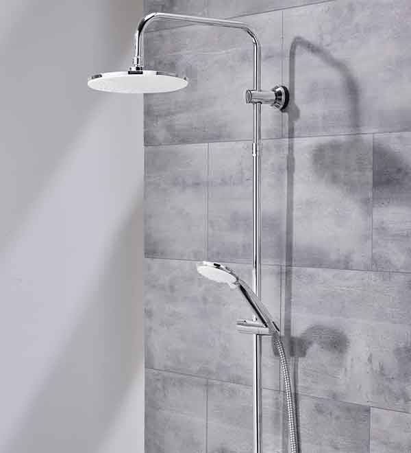 A modern chrome shower system with a rainfall shower head and handheld shower is mounted on a grey tiled wall.