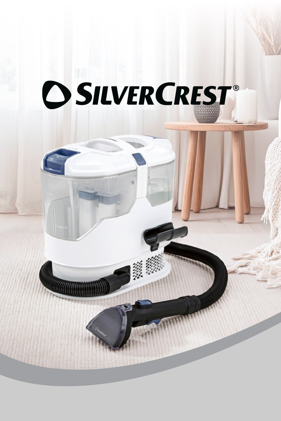 A portable spot carpet cleaner with a hose and nozzle on a light-colored rug.