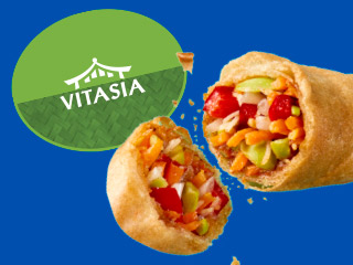 A broken-open Vitasia spring roll reveals a colorful vegetable filling.
