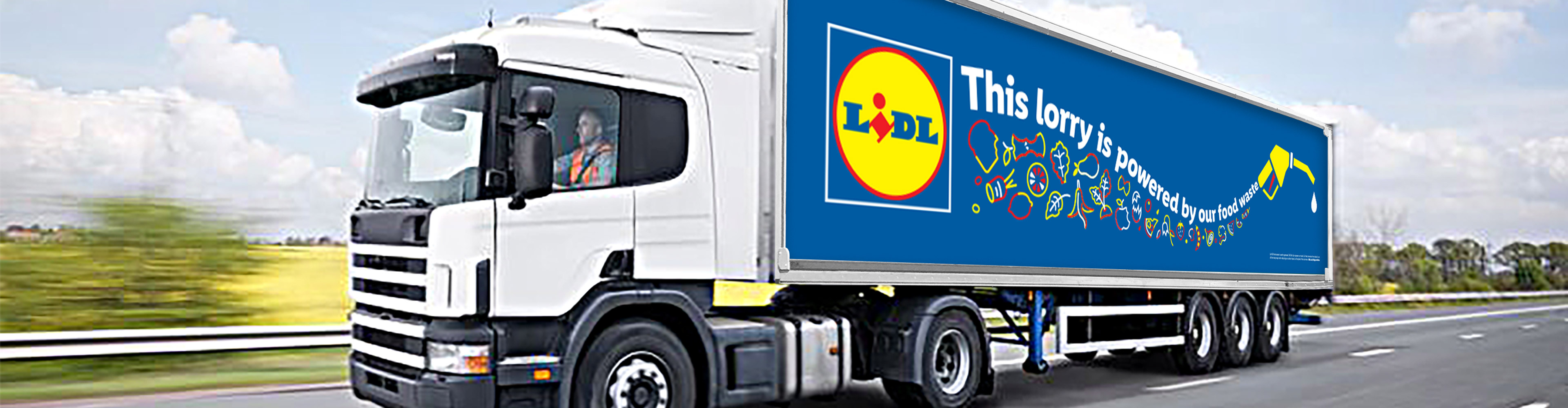 A Lidl lorry, powered by food waste, drives on a highway.