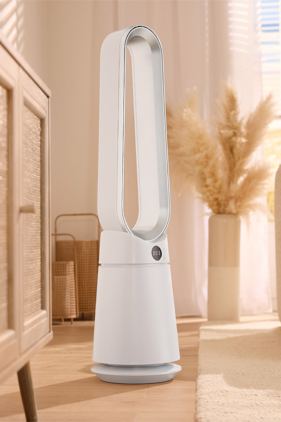 White bladeless tower fan with a digital display in a bright living room