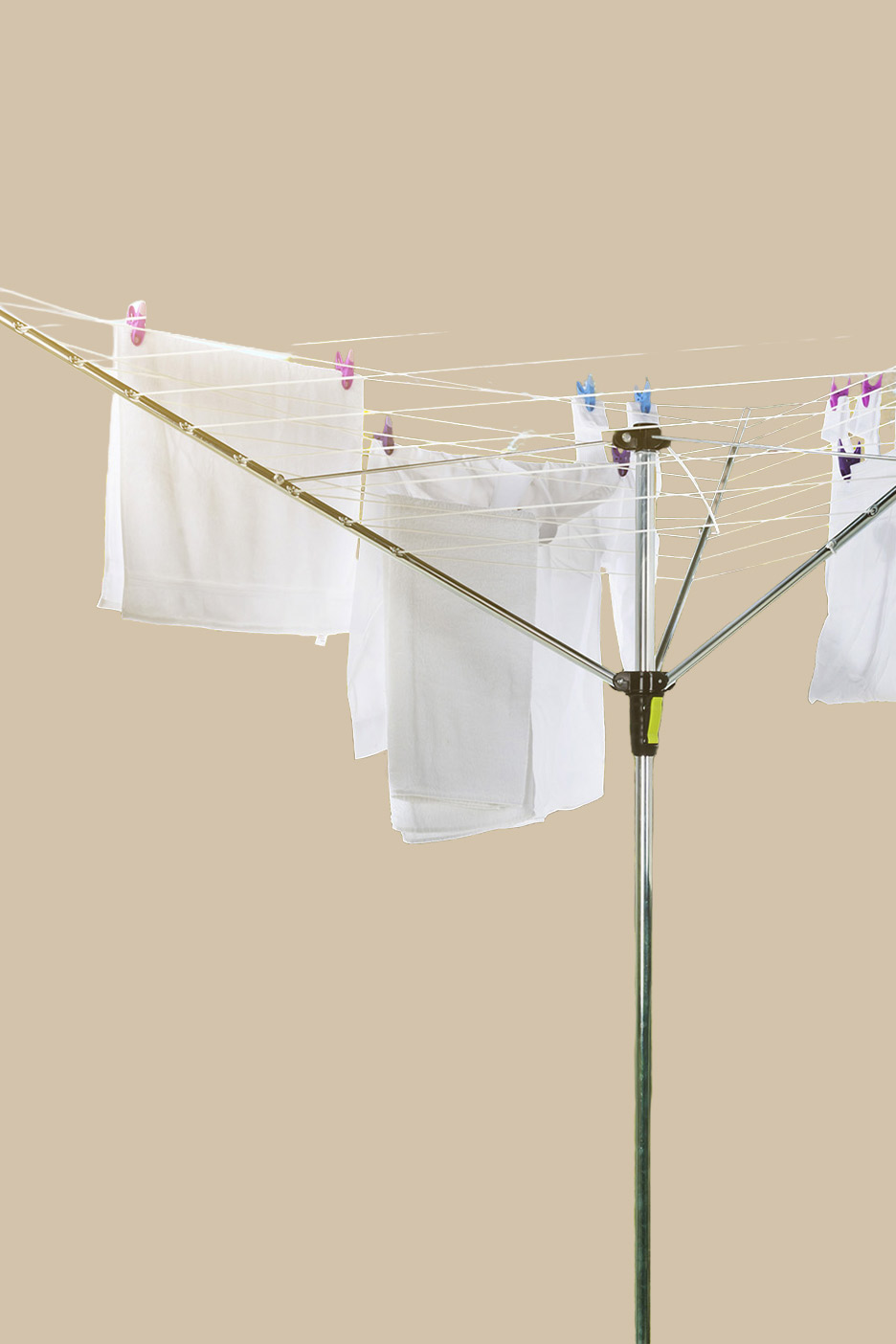 White laundry drying on a rotary clothesline with colorful pegs.