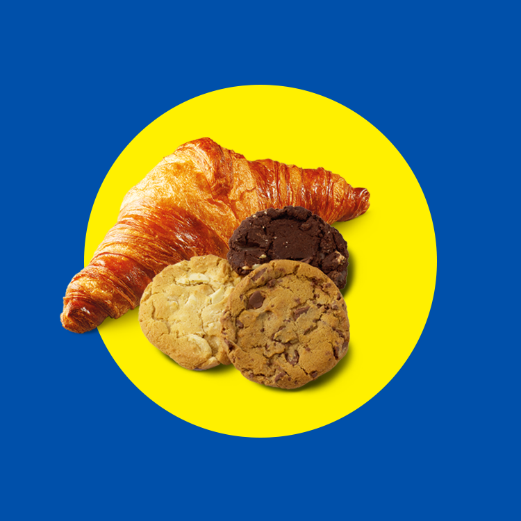 Croissant and three cookies (chocolate chip, white chocolate, double chocolate) on a yellow circle.