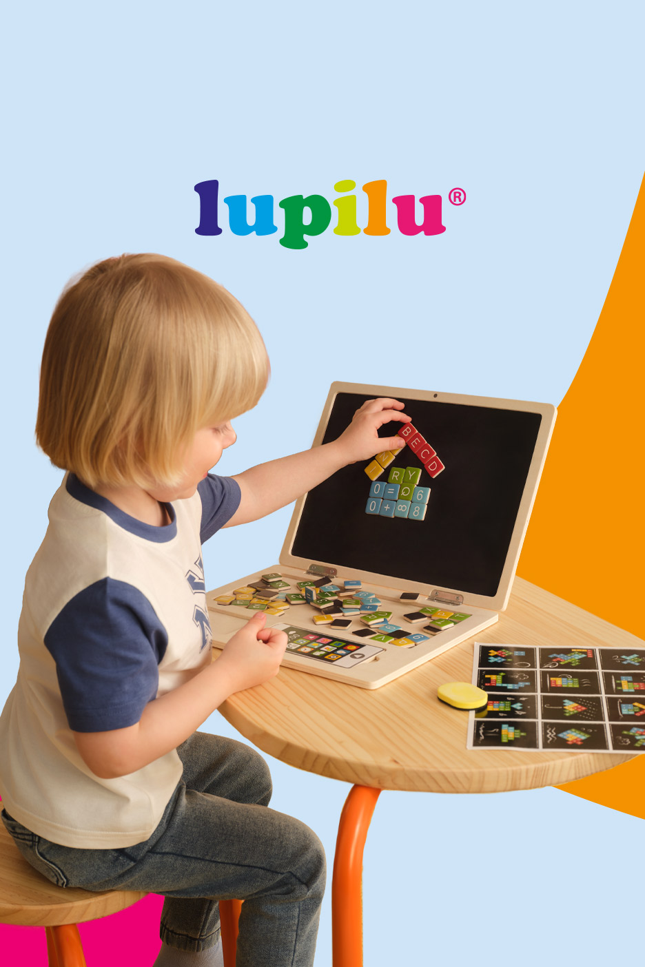 A child plays with a wooden toy laptop, arranging colorful magnetic letters and numbers on its screen.