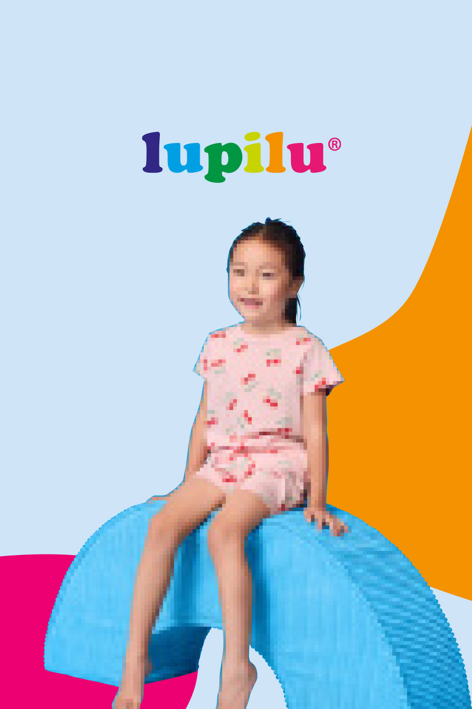 A young girl in pink cherry pajamas sits on a blue textured arch, with a colorful logo above.
