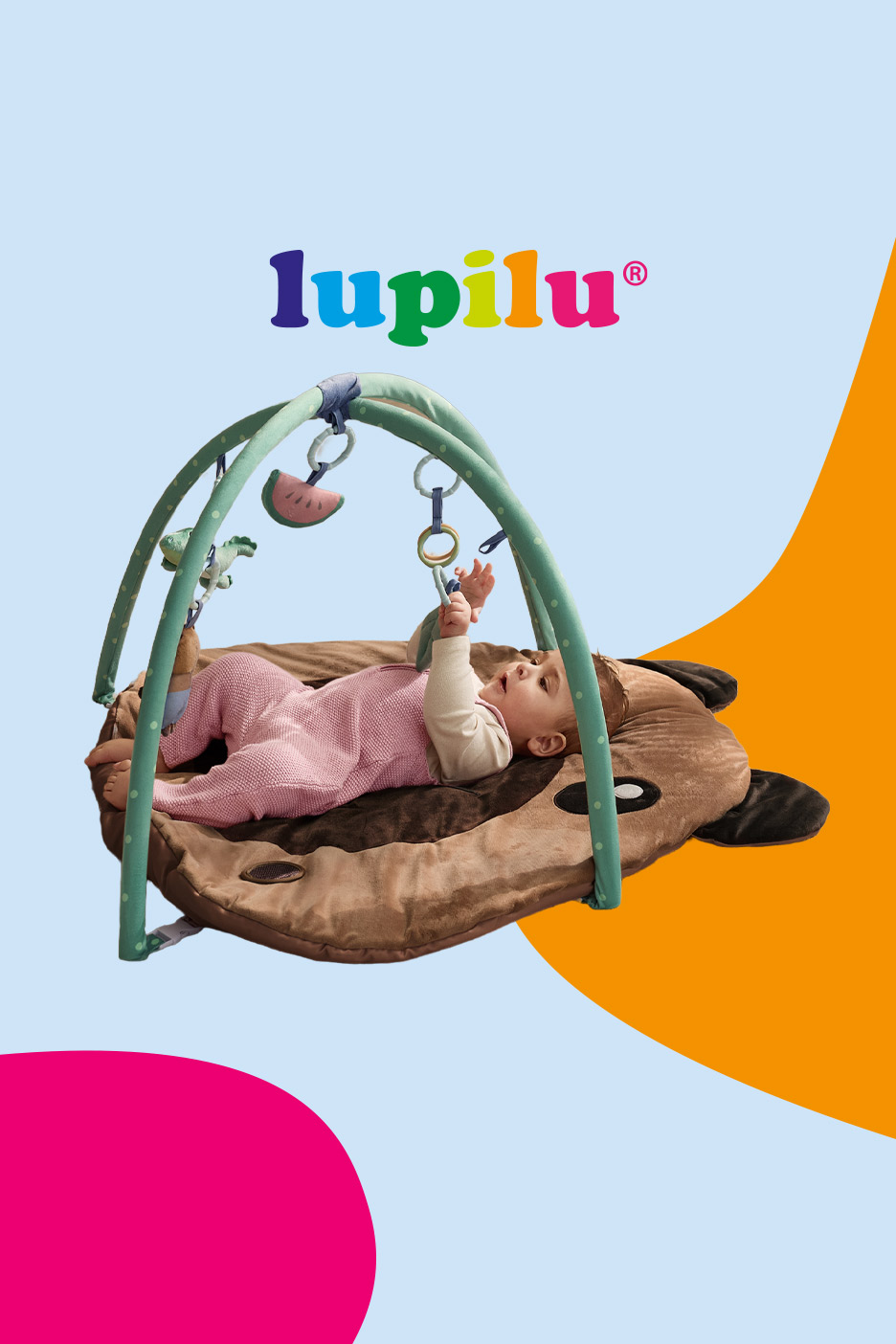 Baby playing on a brown animal-shaped playmat with an activity arch and hanging toys.