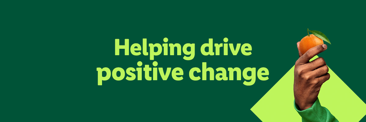 A hand holding an orange with the text 'Helping drive positive change'.