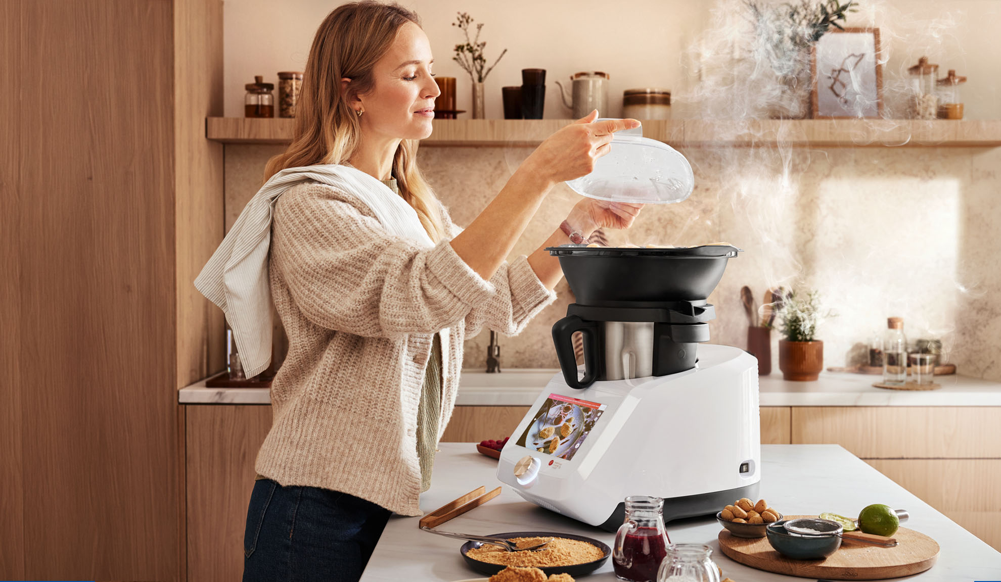 Woman cooking with a kitchen appliance, steam rising, in a modern kitchen.
