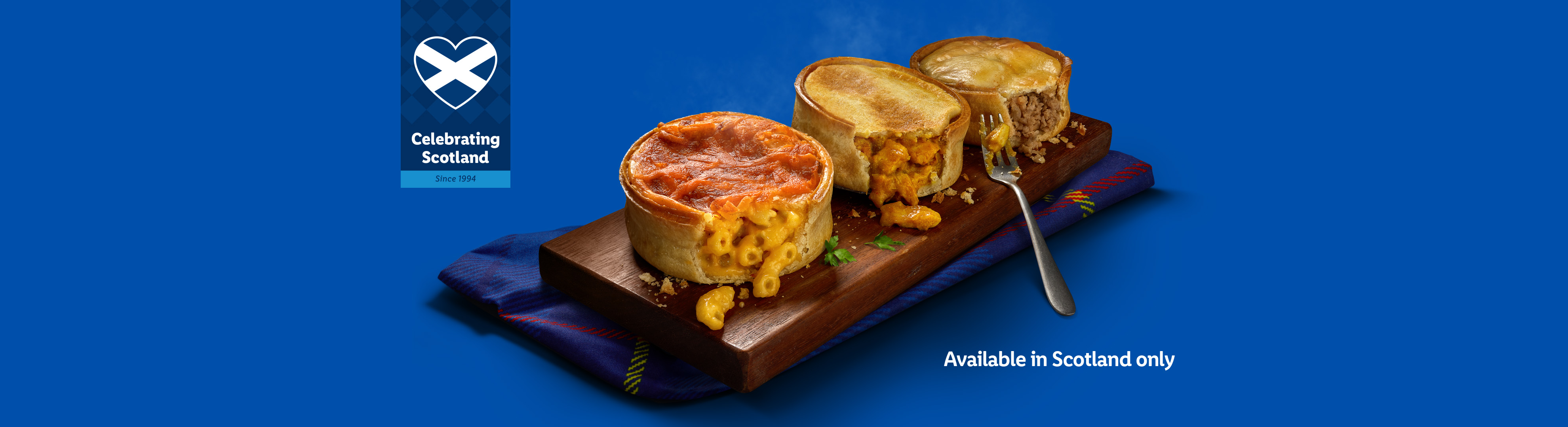 Three Scottish pies (macaroni, chicken curry, mince) on a board, with a 'Celebrating Scotland' logo.