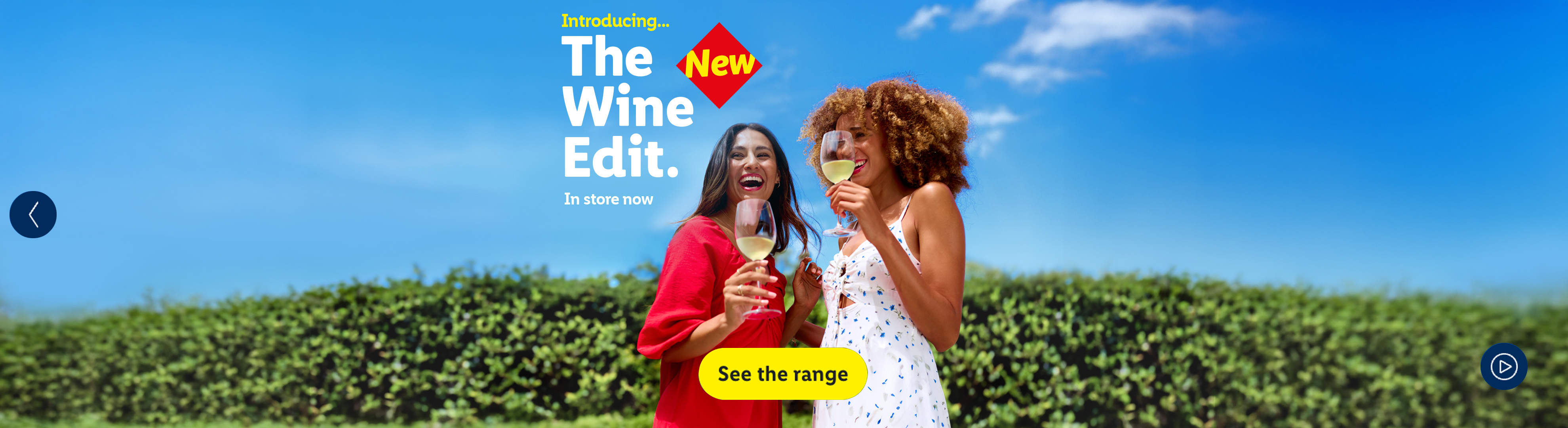 Two women enjoying wine outdoors, promoting 'The New Wine Edit' available in store now.