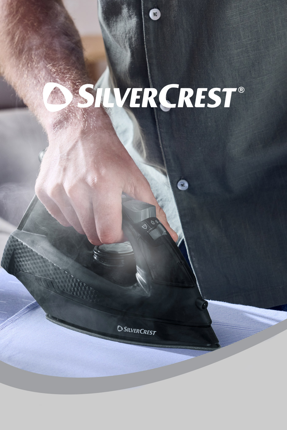 A person ironing a light blue shirt with a black steam iron, steam visible.