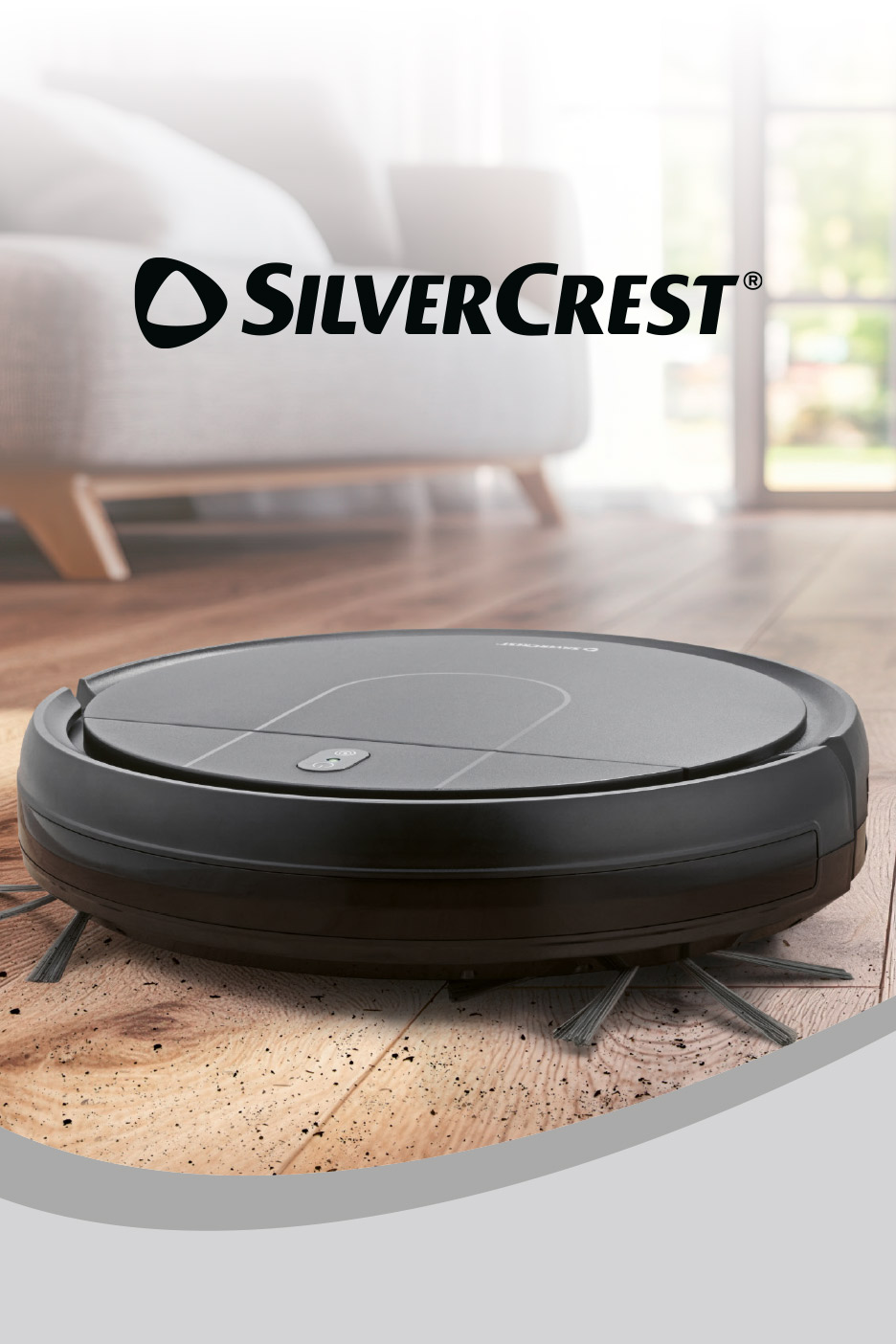 Black robotic vacuum cleaner on a wooden floor in a living room