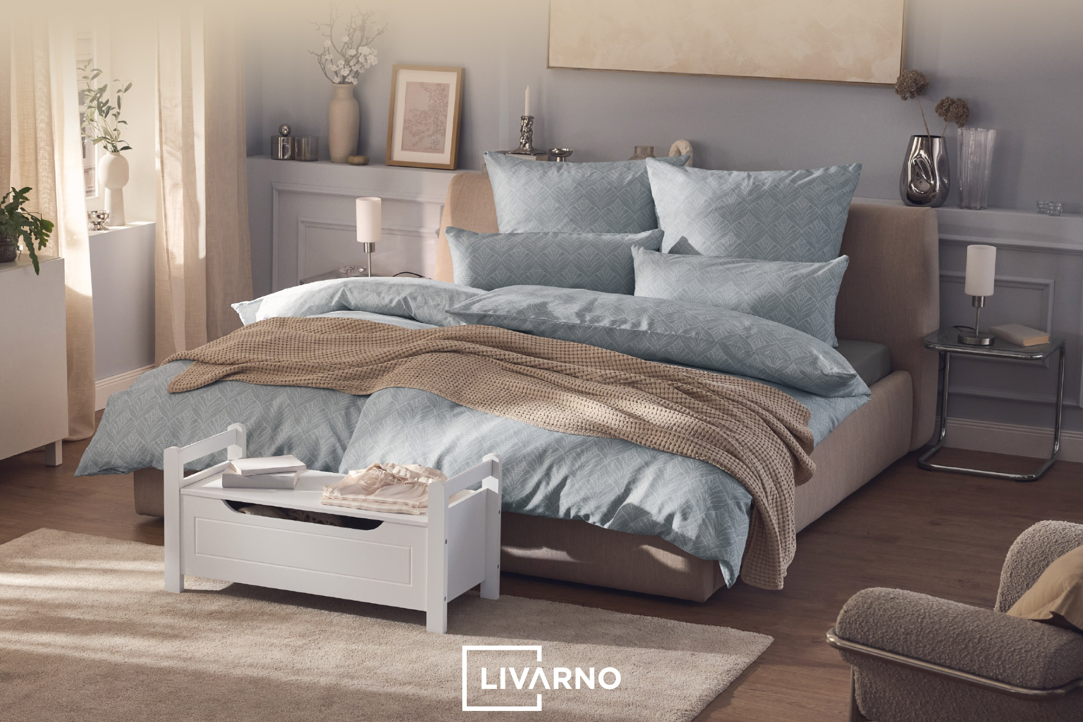 Bedroom with a bed featuring light blue patterned bedding and a beige knitted throw.