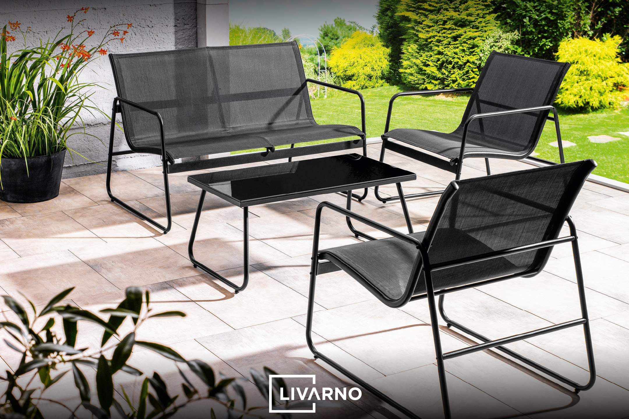Outdoor patio furniture set with a black two-seater sofa, two chairs, and a coffee table.