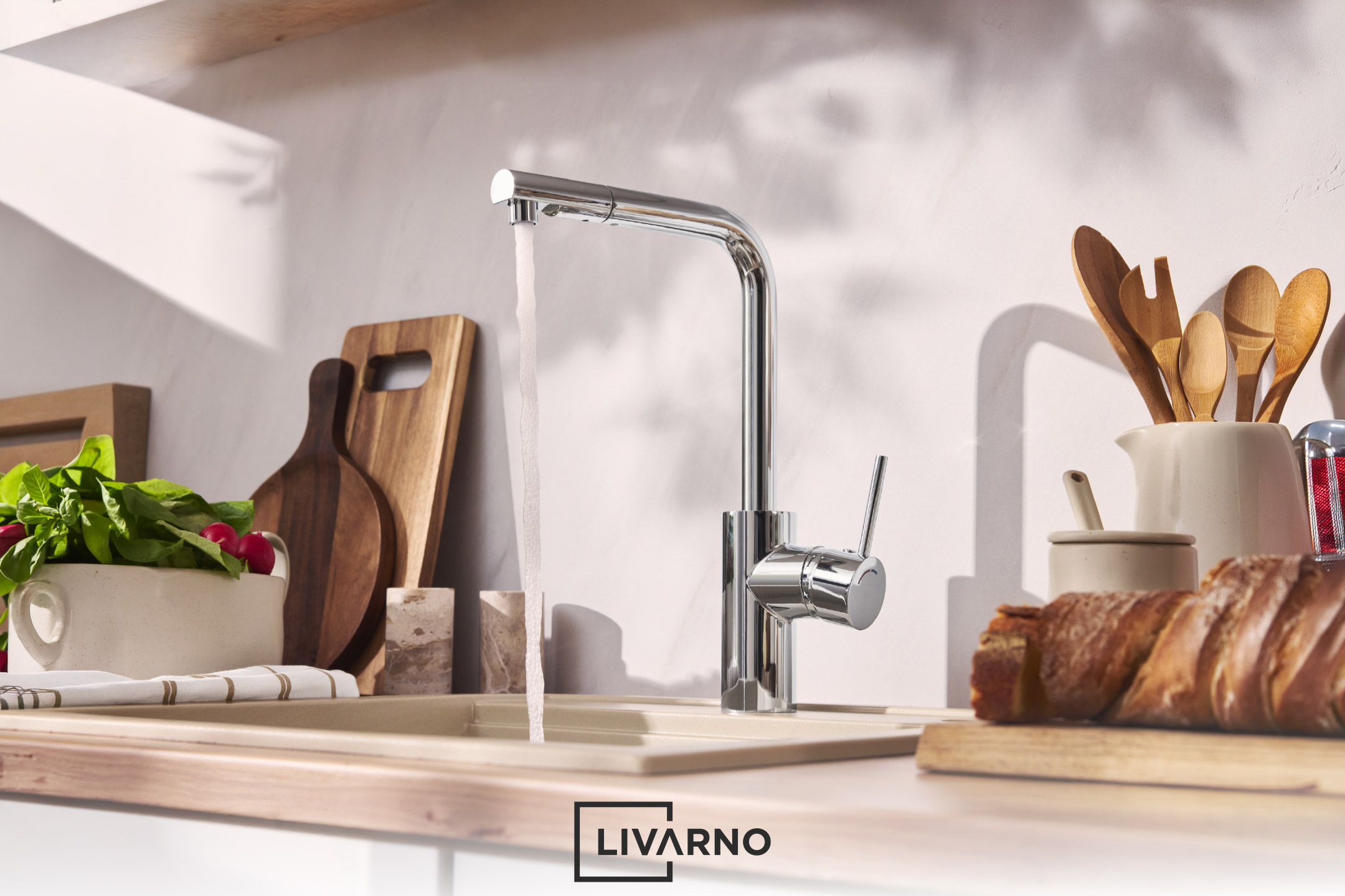 A modern kitchen faucet with running water, a sink, and kitchen utensils.