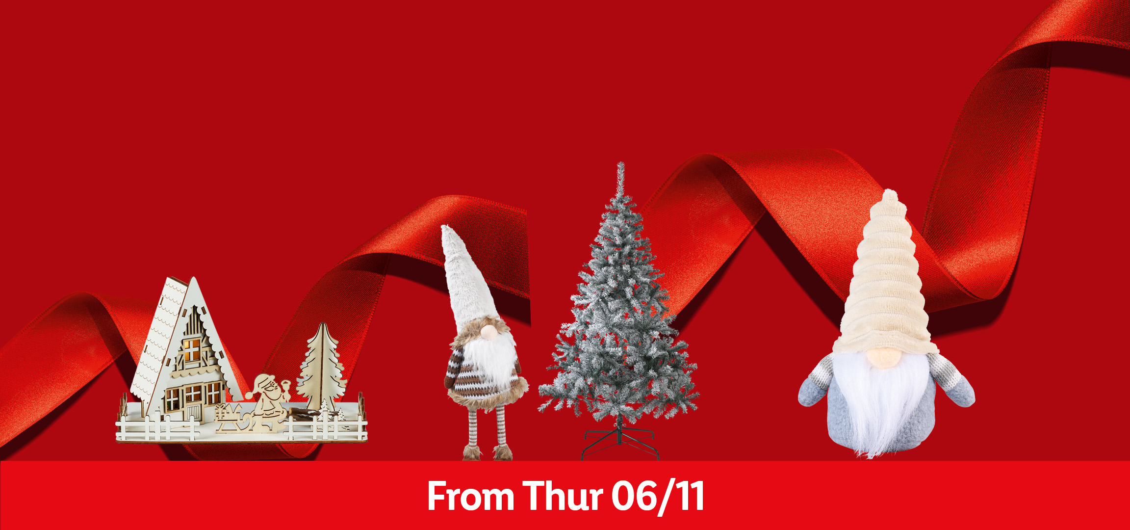 Christmas decorations: wooden houses, purple baubles, a flocked tree, and a gnome, with a red ribbon.