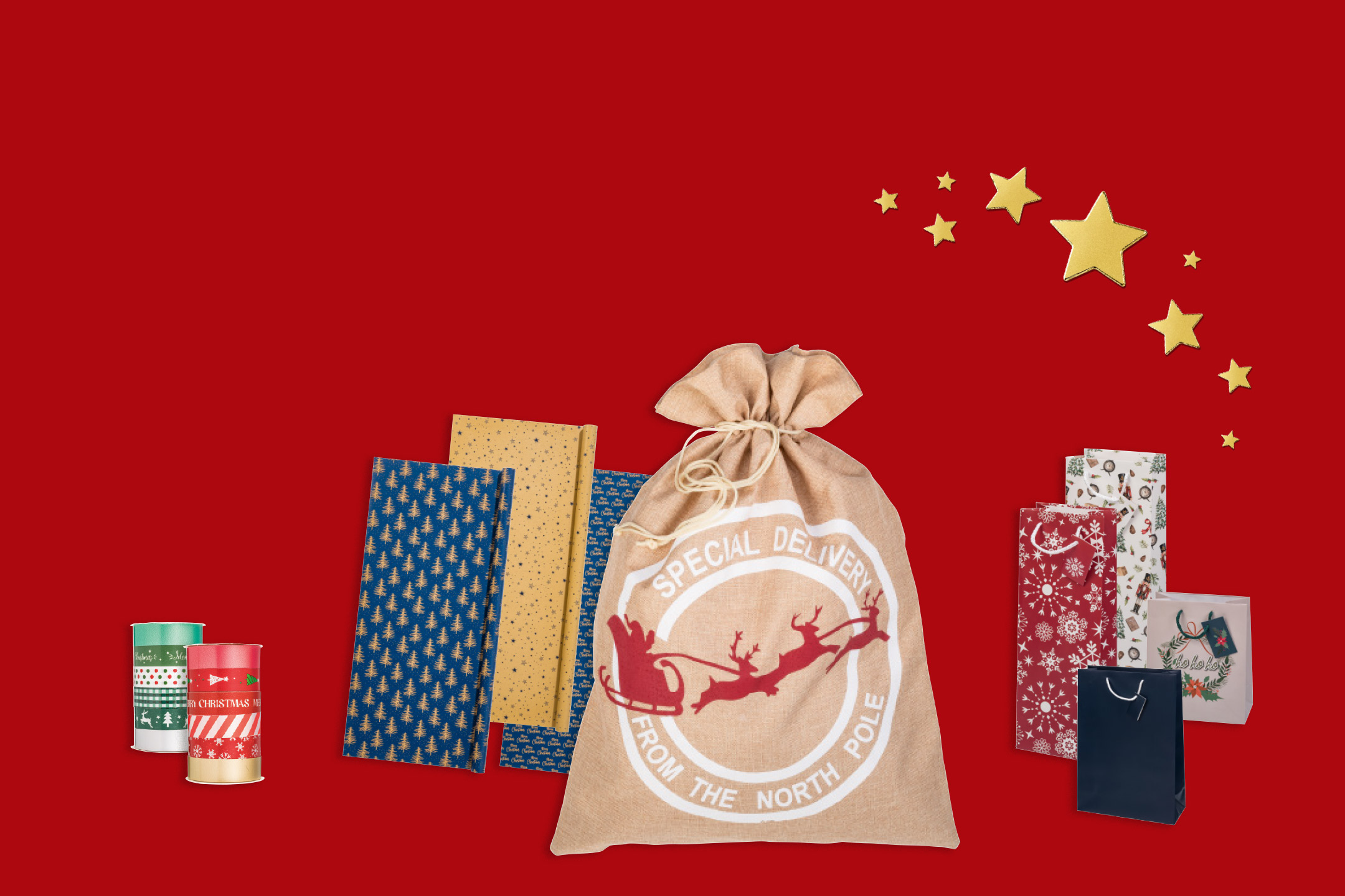 Selection of Christmas gift wrapping accessories, including patterned wrapping paper rolls, gift tags, a burlap Santa sack, and festive gift bags on a red background.