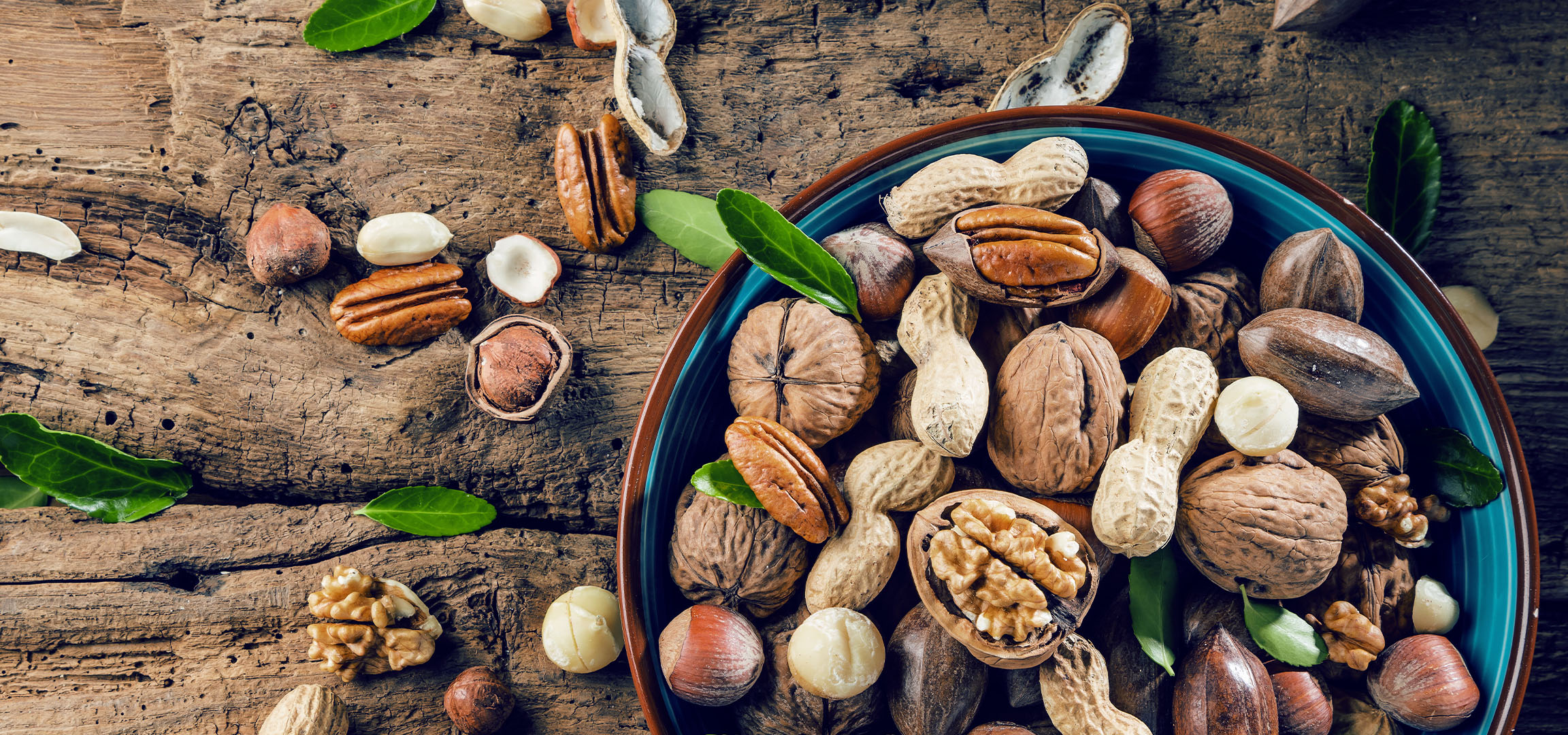 aiLabeling.aiLabelForImageAltText: Mix of nuts and dried fruits in a bowl on a rustic wooden table.