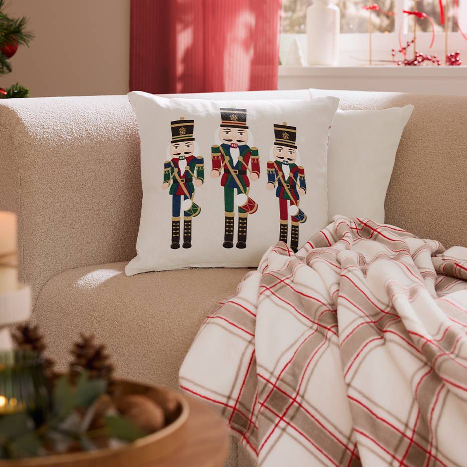 Sofa with Nutcracker Christmas cushion and throw blanket.