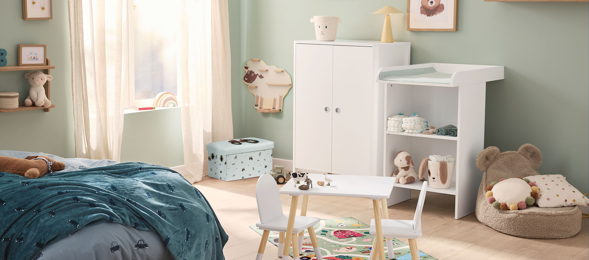 A child's room with a bed, changing table, wardrobe, and a small table with chairs.